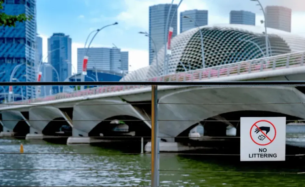No Littering Sign on bridge over river in Singapore city.